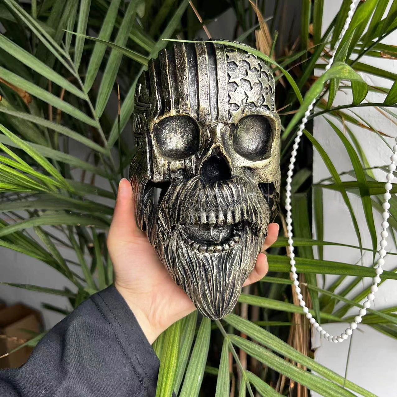 Decorative helmet holder with skull made of synthetic resin
