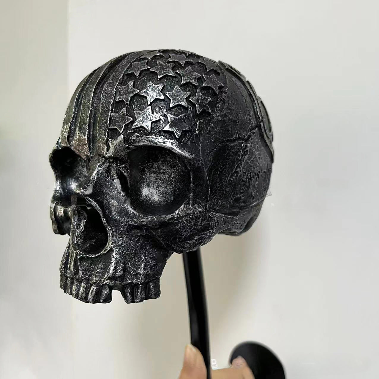 Decorative helmet holder with skull made of synthetic resin